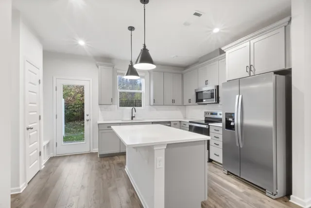 a kitchen with kitchen island a sink stainless steel appliances and window