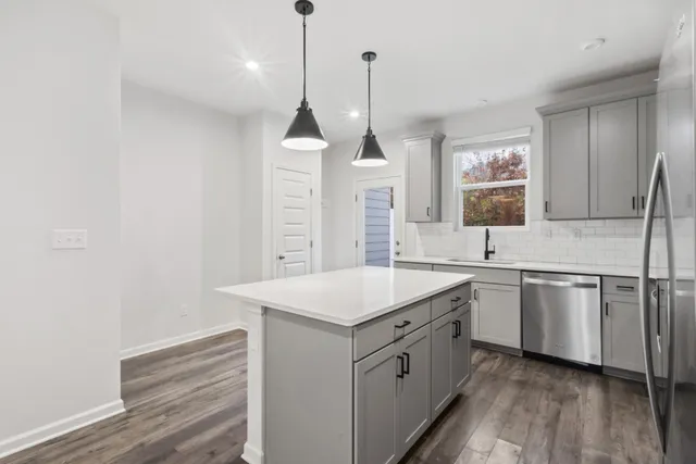 a kitchen with a sink stove and wooden floor