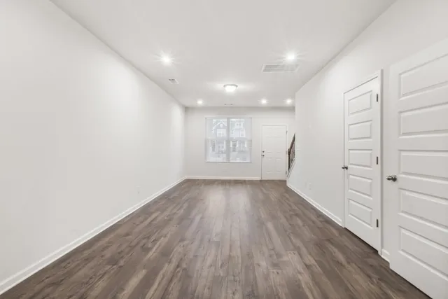 a view of empty room with wooden floor