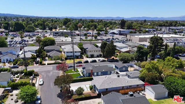 an aerial view of residential houses with outdoor space and parking