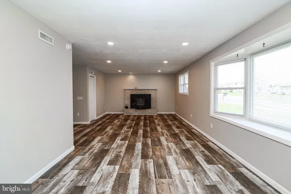 a view of a bedroom with wooden floor and windows