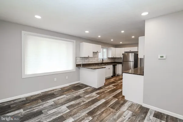 a kitchen with stainless steel appliances granite countertop a refrigerator and a stove top oven