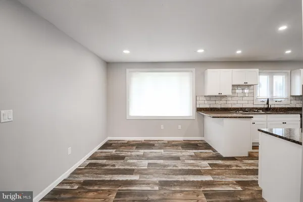a kitchen with granite countertop white cabinets and white appliances