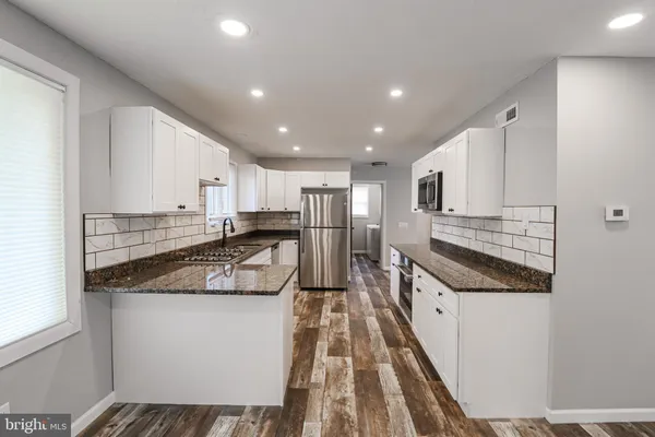 a kitchen with stainless steel appliances granite countertop a sink and cabinets