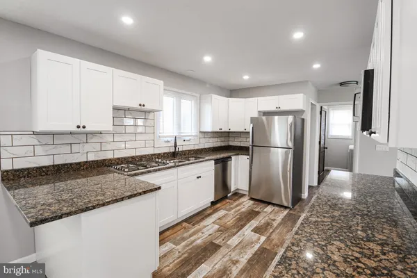 a kitchen with stainless steel appliances granite countertop a refrigerator sink and cabinets