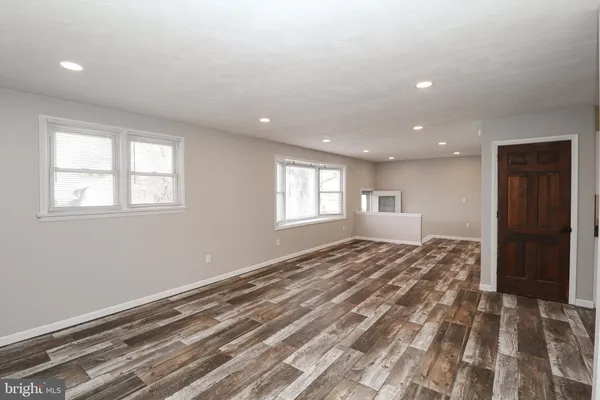 a view of a bedroom with a bed and wooden floor