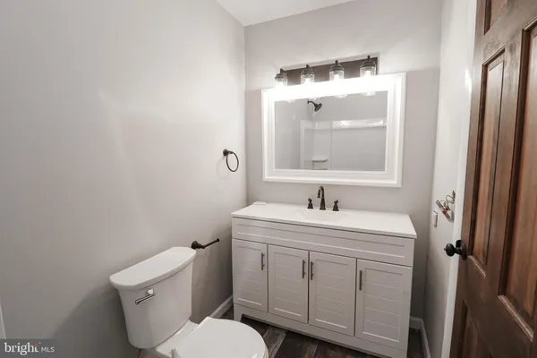 a bathroom with a toilet sink vanity and mirror
