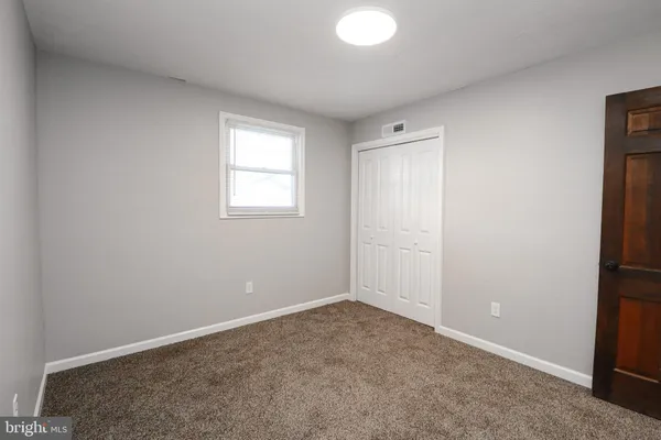 an empty room with windows and closet