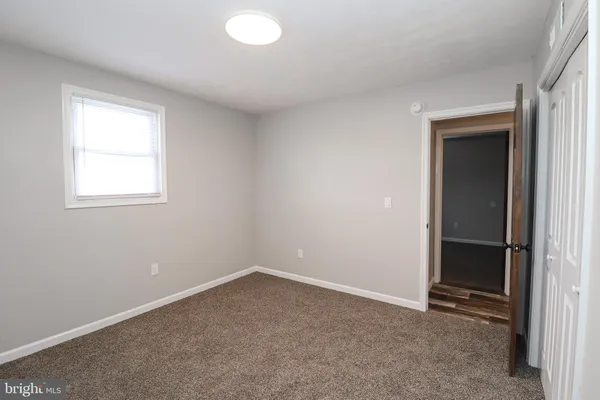 an empty room with windows and closet