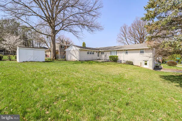 a view of a house with a big yard and large trees