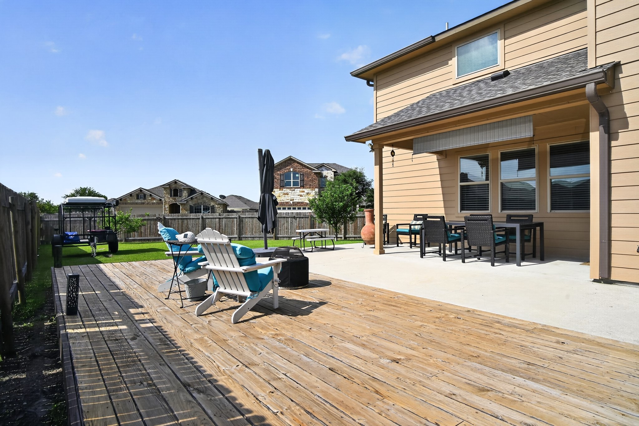16816 Ruggio Road Pflugerville, TX 78660 - Photo 3 of 30 A spacious backyard retreat boasts a substantial wooden deck and an inviting covered patio, perfect for outdoor living.