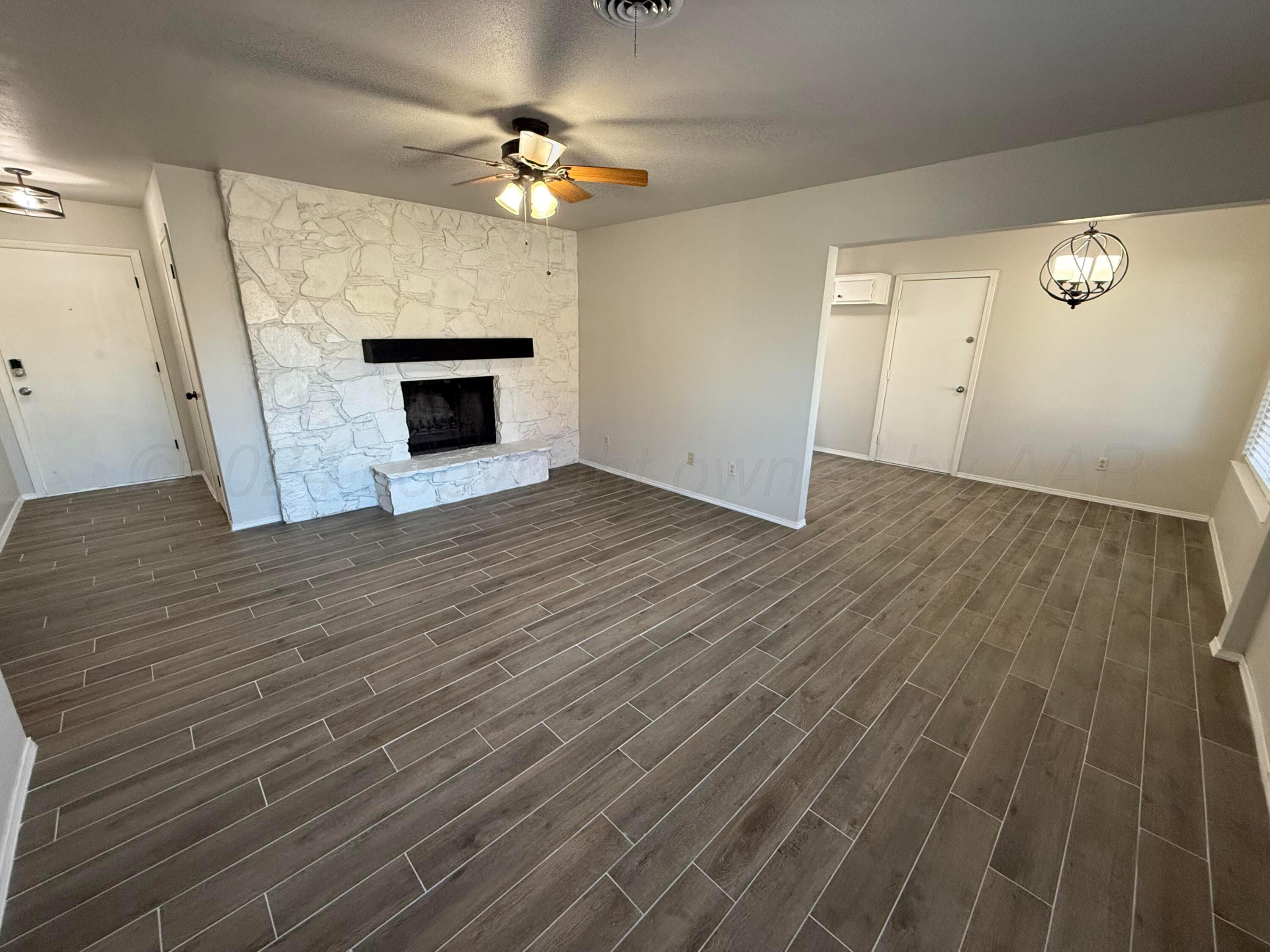 2414 Southwest 49th Avenue Amarillo, TX 79110 - Photo 3 of 28 wooden floor fireplace and natural light in room