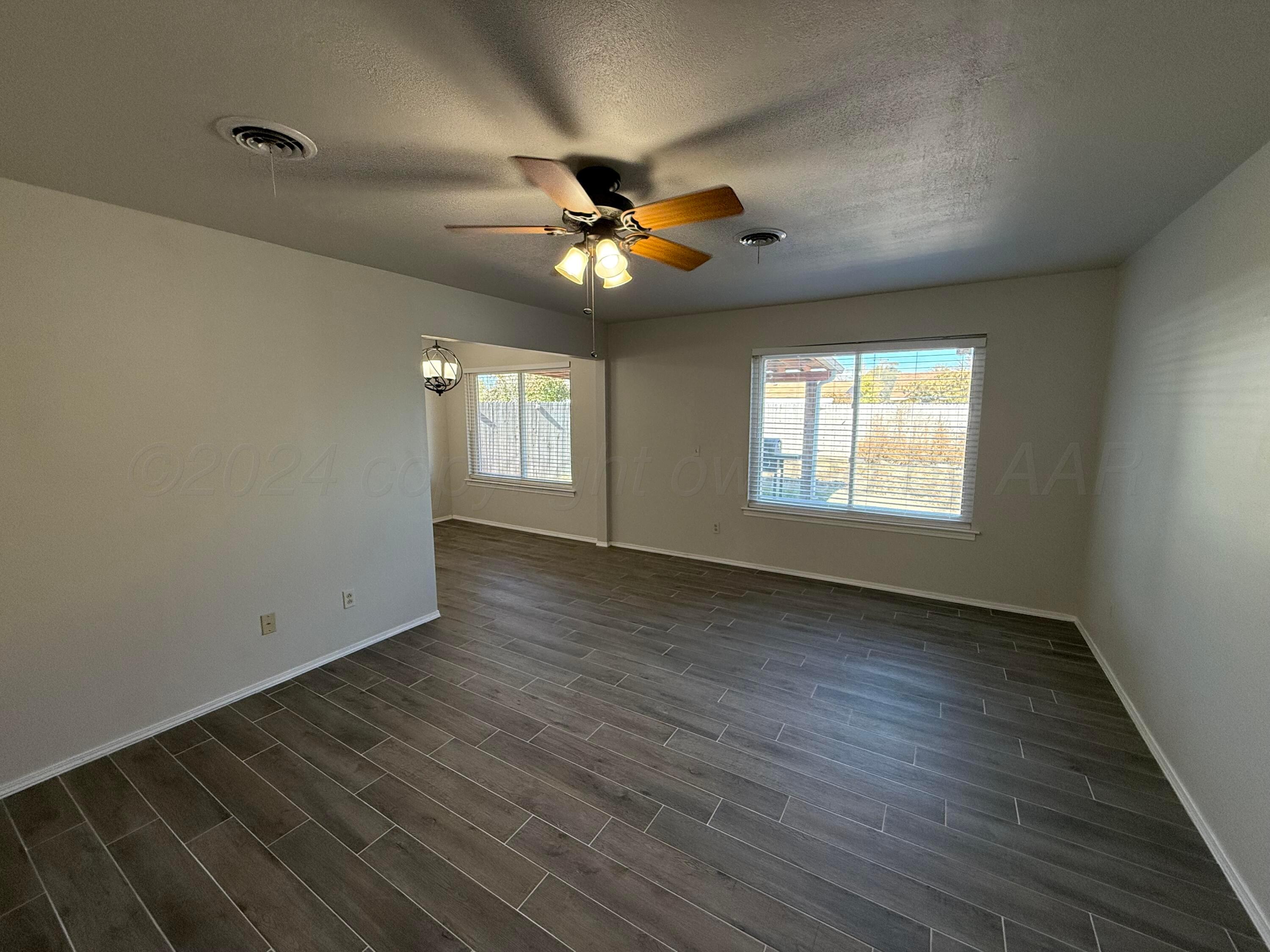 2414 Southwest 49th Avenue Amarillo, TX 79110 - Photo 4 of 28 a view of an empty room with a window and wooden floor