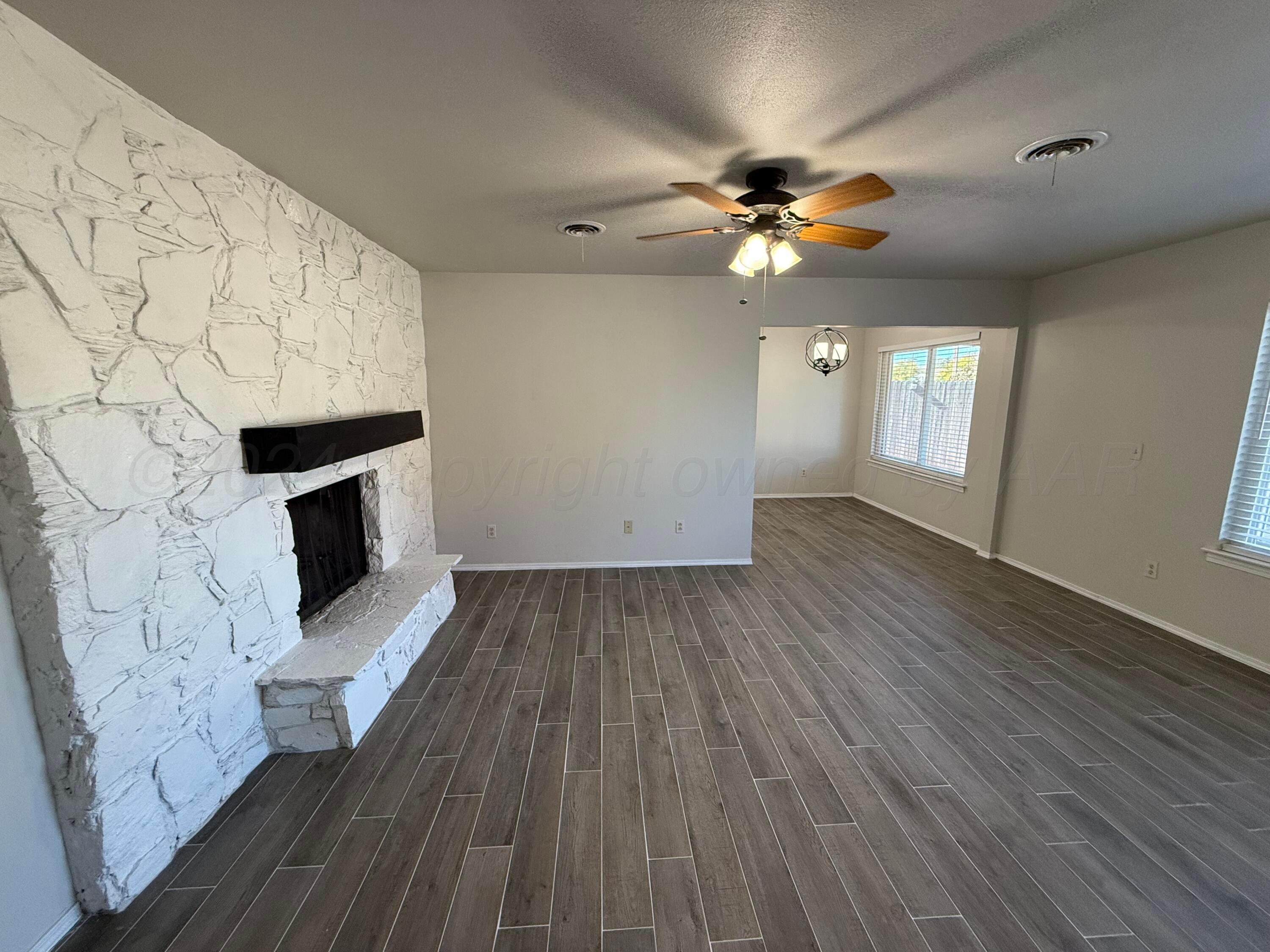 2414 Southwest 49th Avenue Amarillo, TX 79110 - Photo 5 of 28 wooden floor in an empty room with a fireplace