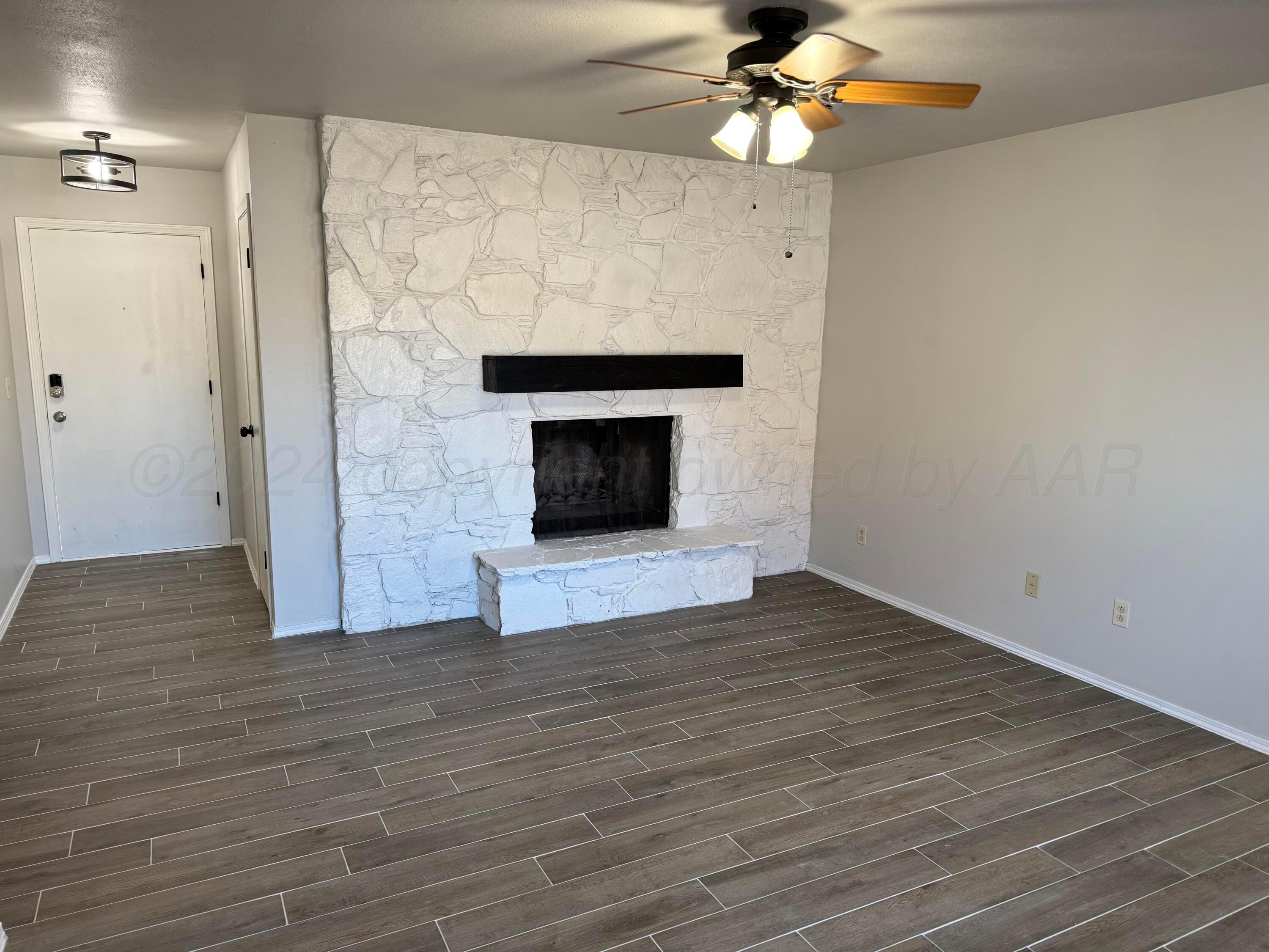 2414 Southwest 49th Avenue Amarillo, TX 79110 - Photo 6 of 28 a view of an empty room with wooden floor fireplace and a window