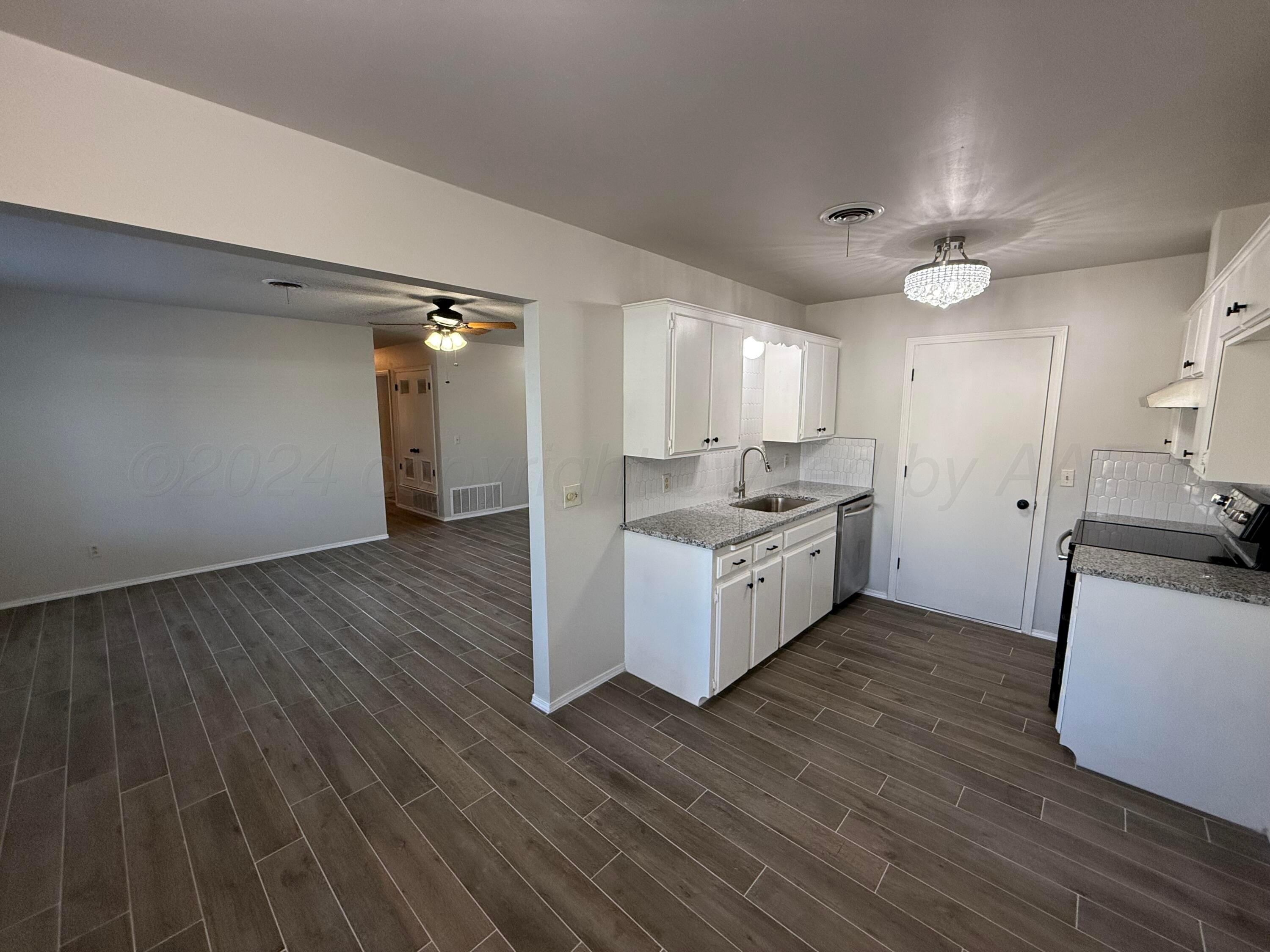 2414 Southwest 49th Avenue Amarillo, TX 79110 - Photo 8 of 28 a kitchen with a sink cabinets and wooden floor