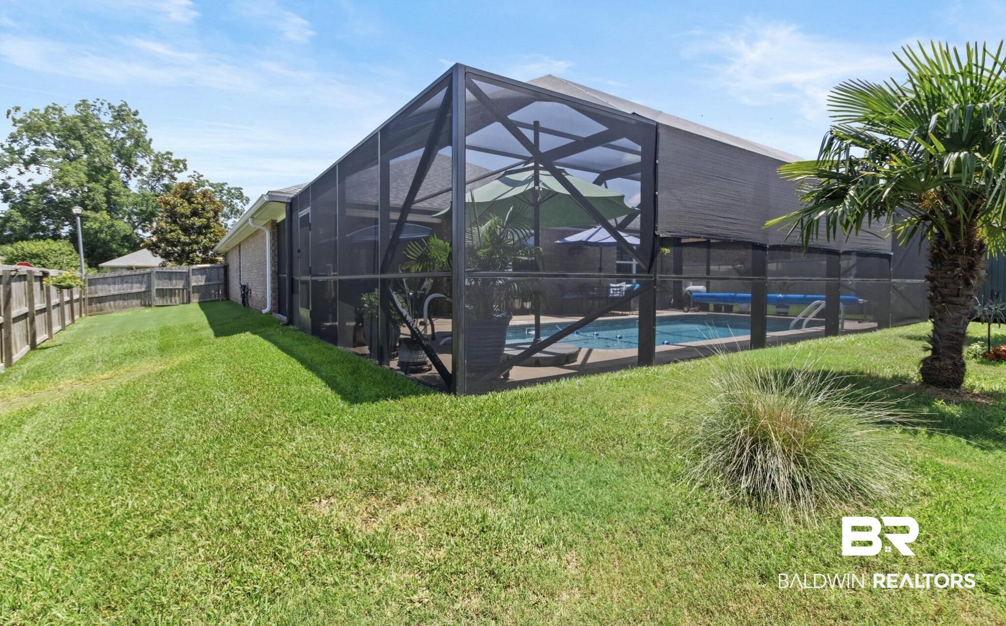 1676 Abbey Loop Foley, AL 36535 - Photo 24 of 31 Screened pool enclosure featuring a concrete deck, integrated swimming pool, and a side yard with a wooden fence