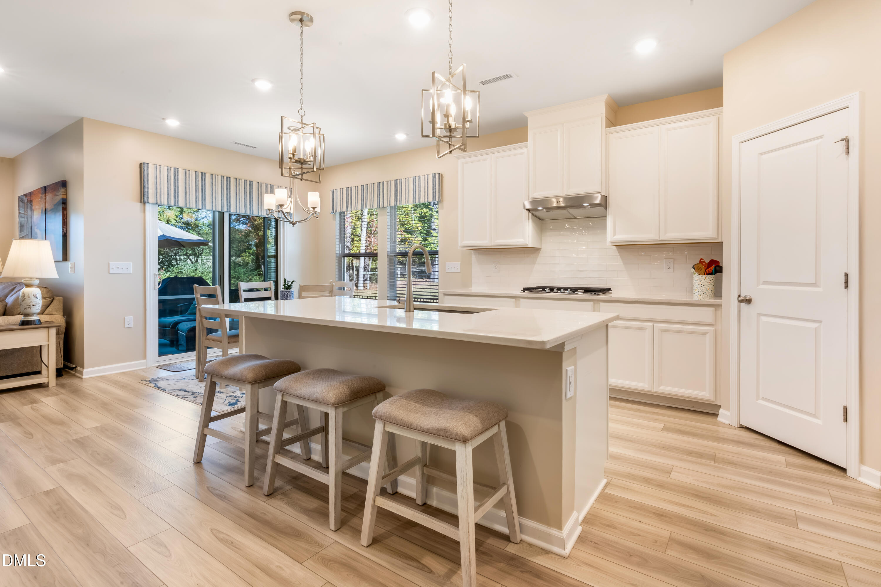 8017 Toddwick Court Raleigh, NC 27616 - Photo 5 of 30 a kitchen with granite countertop a table chairs stove and white cabinets