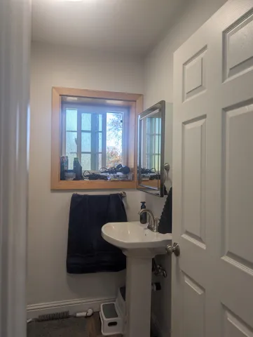 a bathroom with a sink a mirror and a window