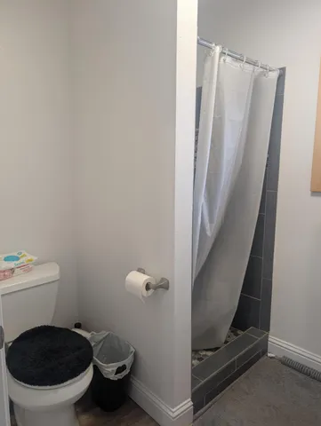 a bathroom with a granite countertop toilet and a sink