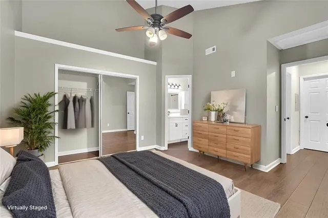 a bedroom with a bed potted plant with the wooden floor