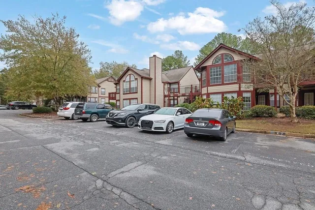 a view of road with card parked on side and retail shops