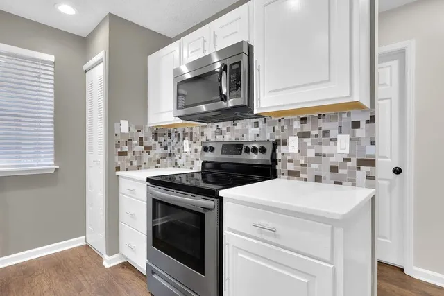 a kitchen with microwave cabinets and stove top oven