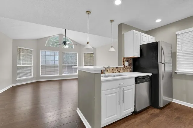 a kitchen with kitchen island white cabinets and stainless steel appliances