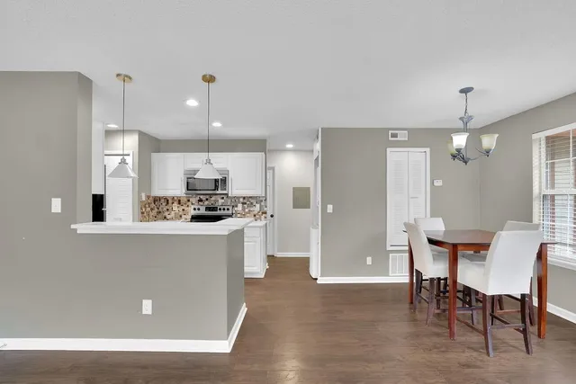 a kitchen with a refrigerator a dining table and chairs