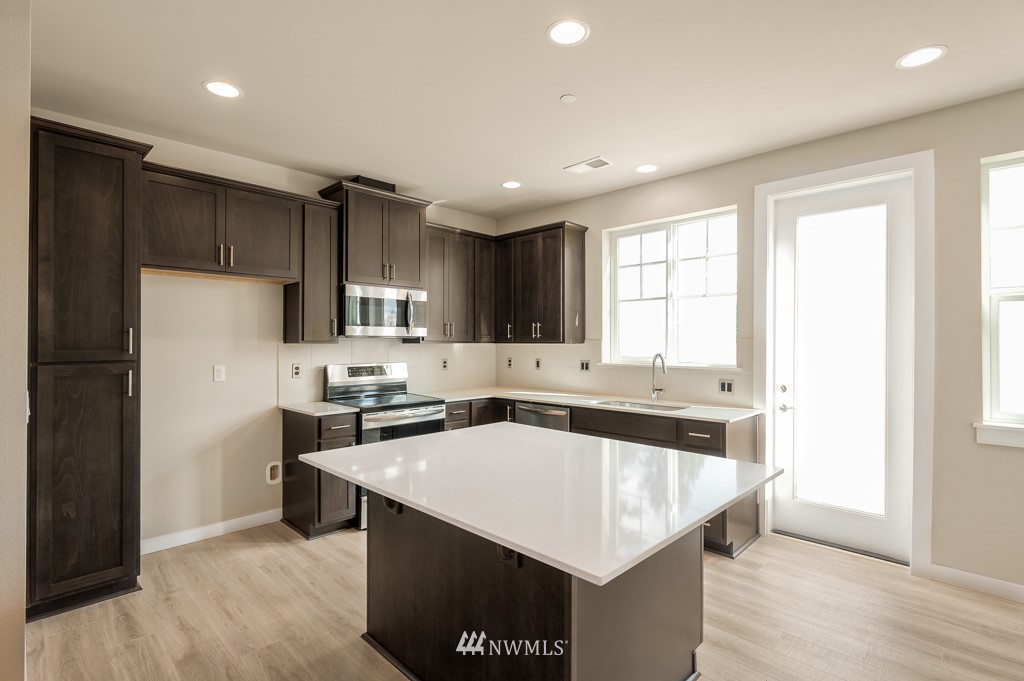 1621 Seattle Hill Road, Unit CC3 Bothell, WA 98012 - Photo 2 of 25 a kitchen with a sink a stove a refrigerator a center island and a window