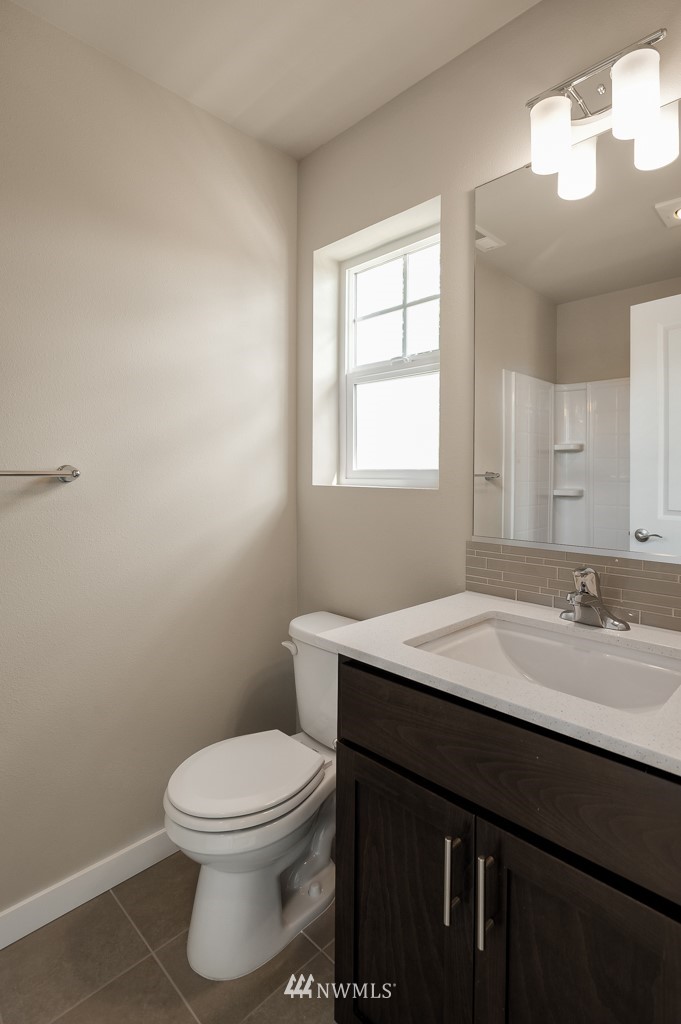 1621 Seattle Hill Road, Unit CC3 Bothell, WA 98012 - Photo 18 of 25 a bathroom with a granite countertop toilet a sink and a mirror