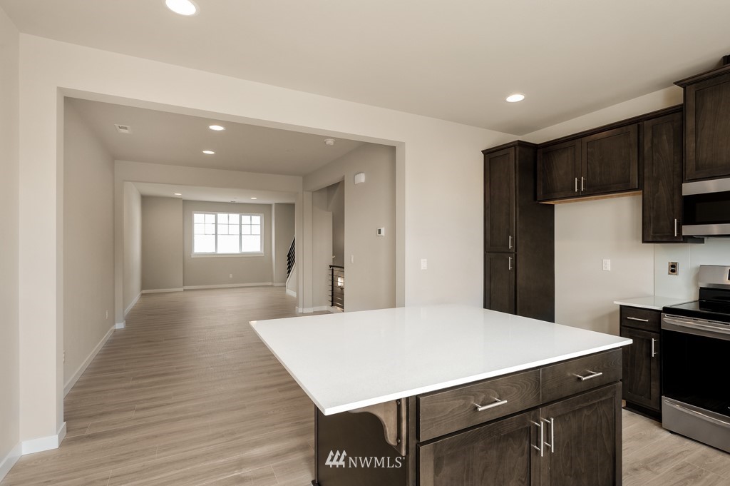1621 Seattle Hill Road, Unit CC3 Bothell, WA 98012 - Photo 6 of 25 a kitchen with kitchen island a sink dishwasher a stove and a refrigerator with wooden floor