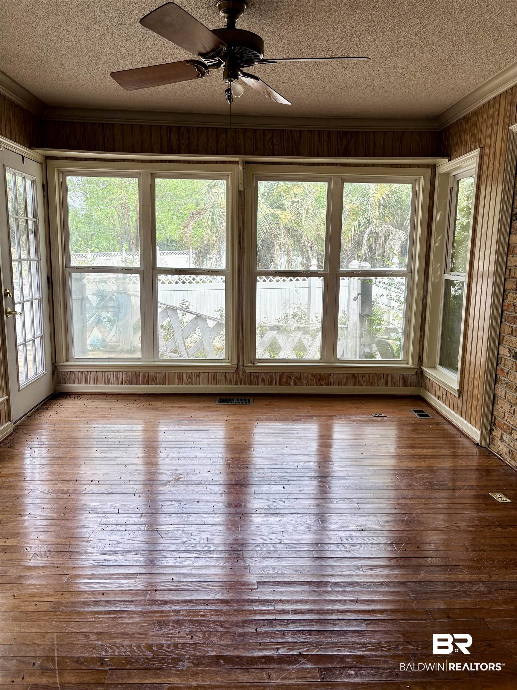 1018 Bates Road Evergreen, AL 36401 - Photo 14 of 21 Unfurnished sunroom with ornamental molding, hardwood / wood-style flooring, a textured ceiling, and wooden walls