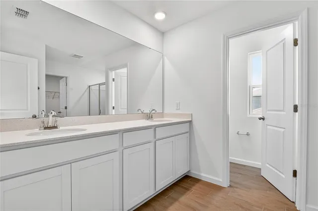 a bathroom with double vanity sinks and a mirror