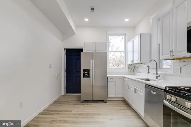 a view of a kitchen with a sink a stove and cabinets