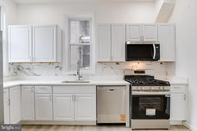 a view of a kitchen with a sink and a stove top oven