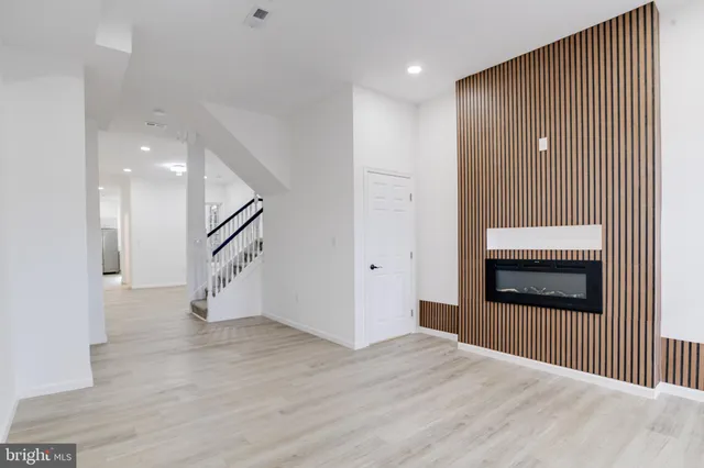 a view of a hallway with wooden floor and entryway