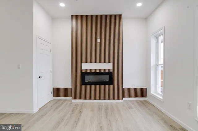 a view of an empty room with a window and fireplace