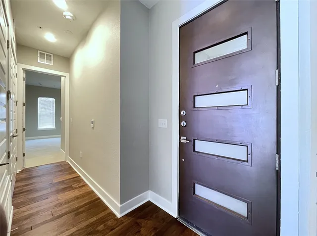 a view of a hallway with wooden floor