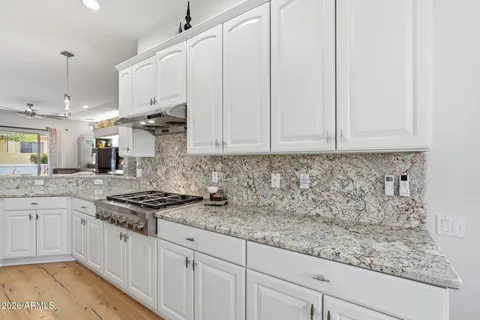 a kitchen with granite countertop white cabinets and white appliances
