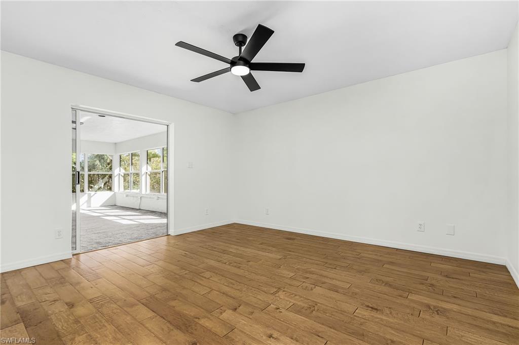 670 27th Street Northwest Naples, FL 34120 - Photo 11 of 39 an empty room with wooden floor and windows