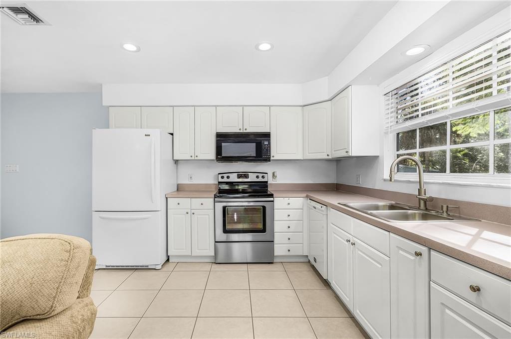 670 27th Street Northwest Naples, FL 34120 - Photo 21 of 39 a kitchen with a sink a stove and a refrigerator