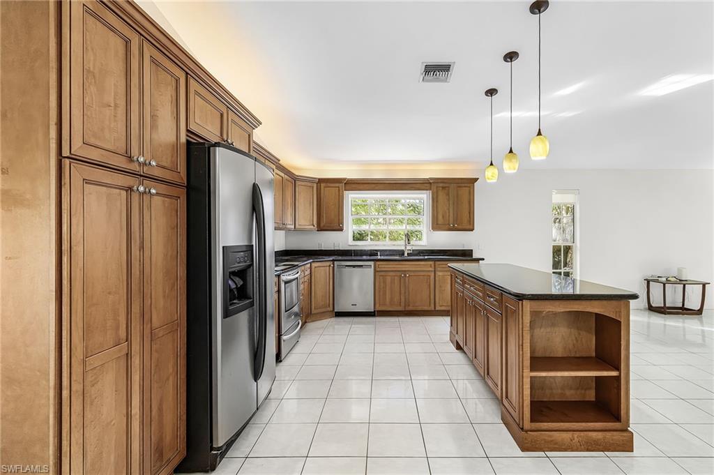 670 27th Street Northwest Naples, FL 34120 - Photo 10 of 39 a kitchen with stainless steel appliances granite countertop a refrigerator a sink and a stove