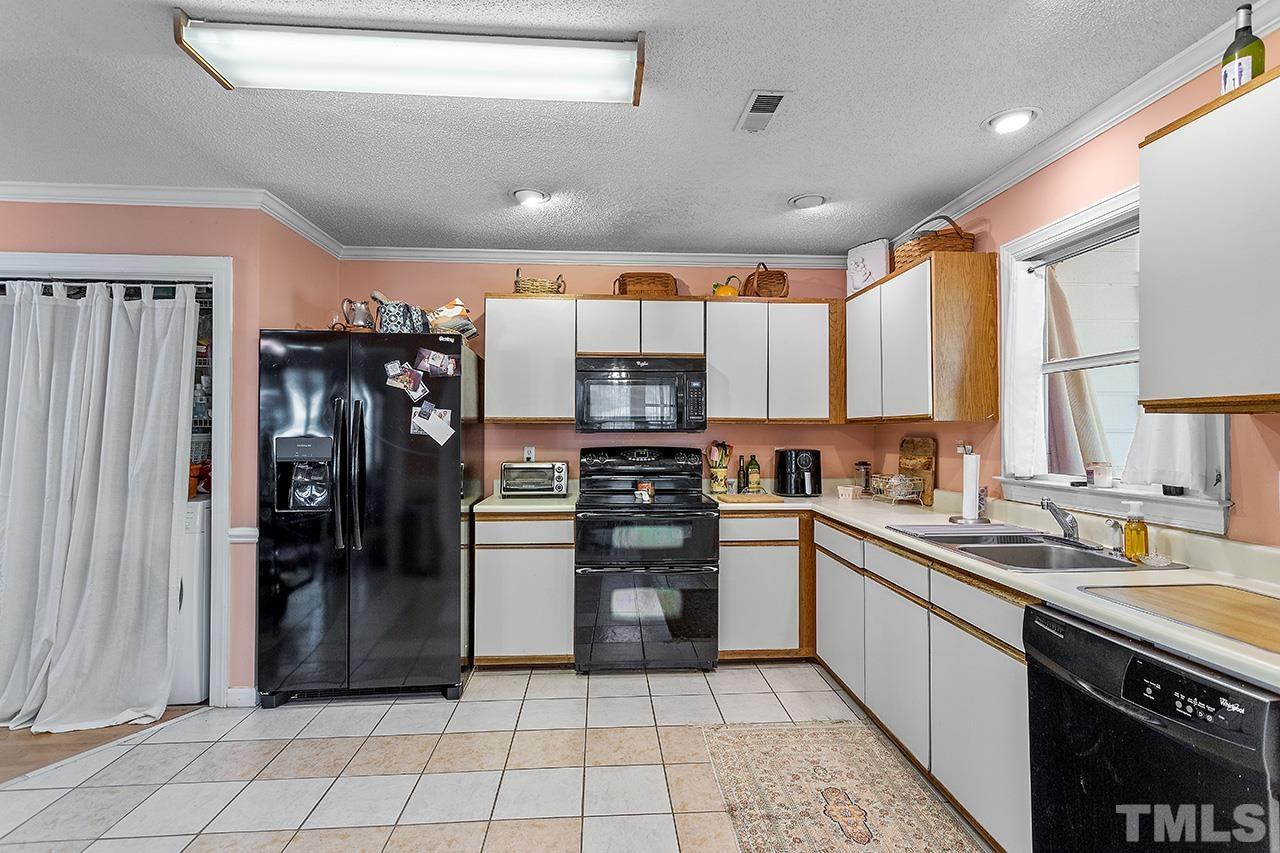 4200 Settlement Drive Durham, NC 27713 - Photo 15 of 32 a kitchen with stainless steel appliances granite countertop a refrigerator and a sink