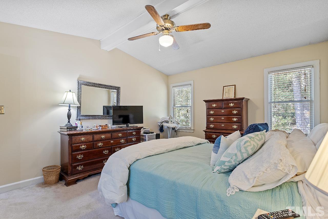 4200 Settlement Drive Durham, NC 27713 - Photo 30 of 32 a bedroom with a bed a dresser and a flat screen tv