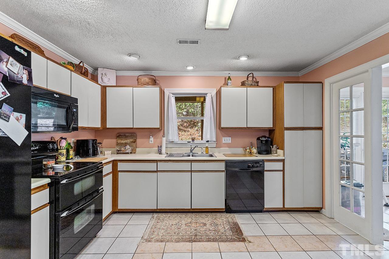 4200 Settlement Drive Durham, NC 27713 - Photo 10 of 32 a kitchen with stainless steel appliances granite countertop a sink a stove a refrigerator cabinets and a window