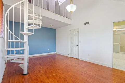 a view of a hallway with a ceiling fan and wooden floor