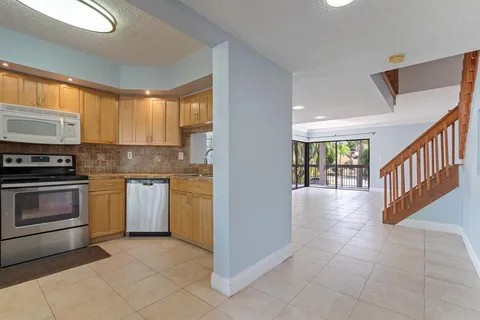 a kitchen with granite countertop a stove a sink and a microwave