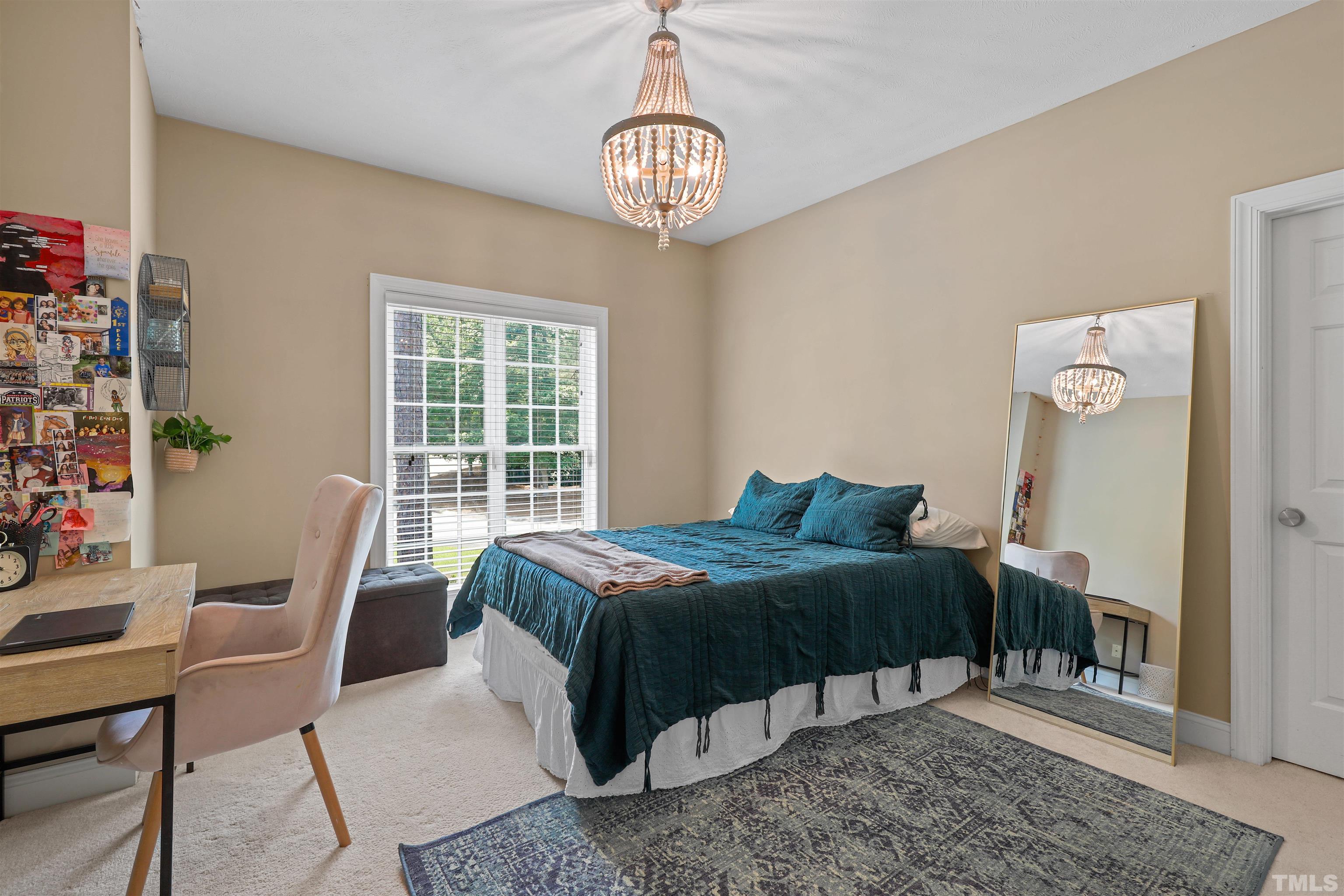 655 Elk Road Southern Pines, NC 28387 - Photo 27 of 45 a bedroom with a bed and a chandelier