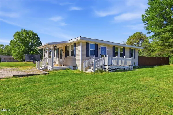 a view of a house with a yard and sitting area